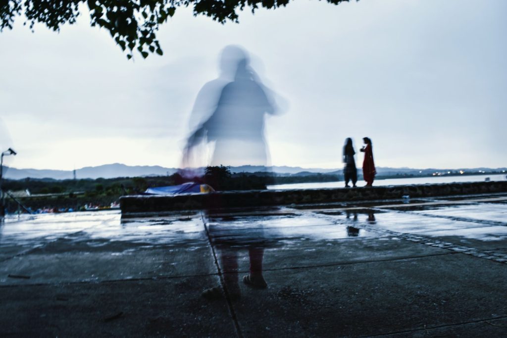 An apparition of a person beside a lake.