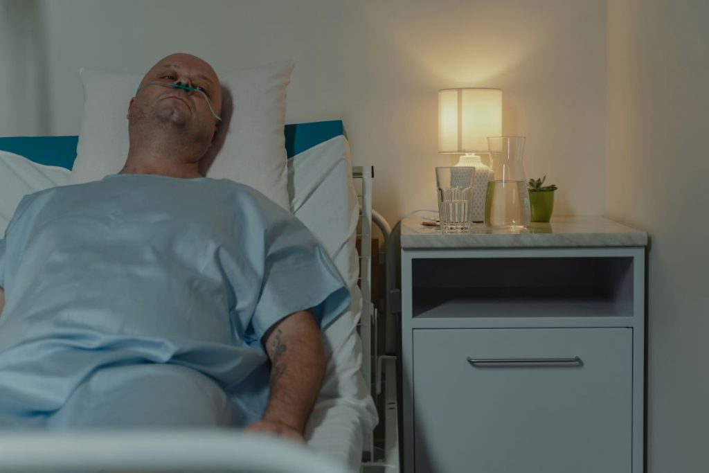 A sick man lying on the hospital bed.