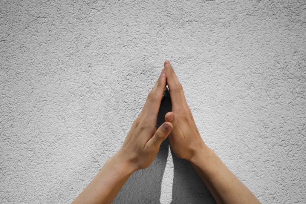 A man steepling his fingers over rock.