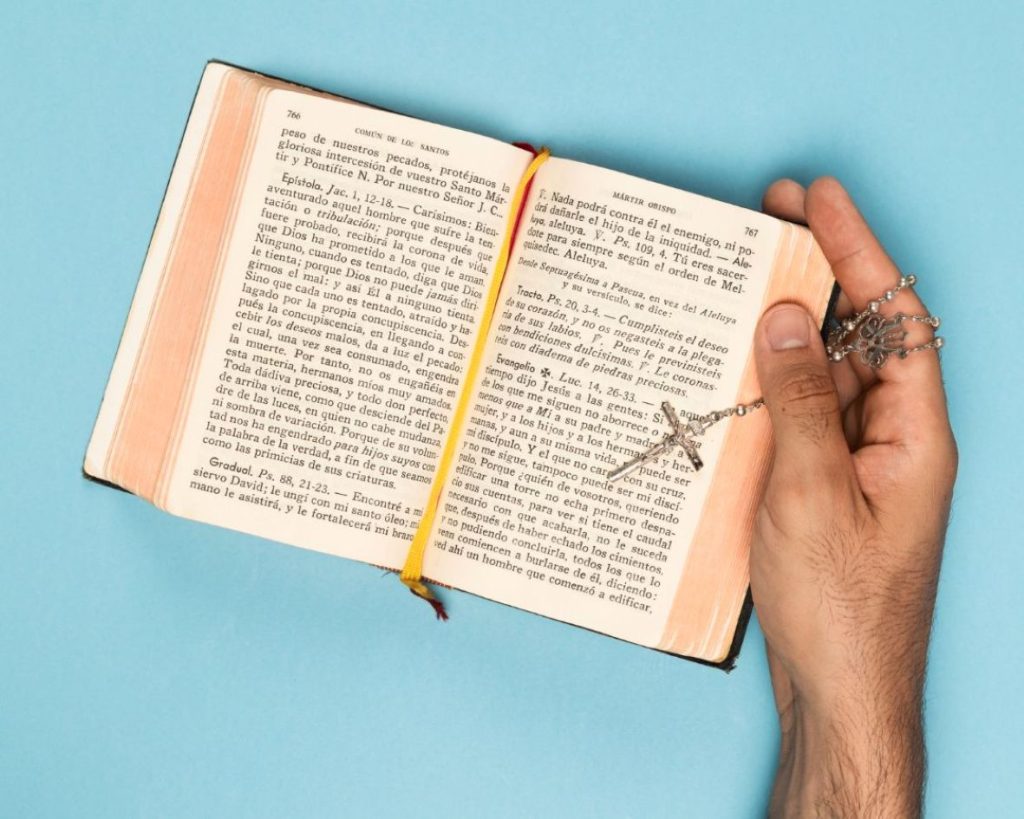 A man reading the Bible diligently with a rosary.