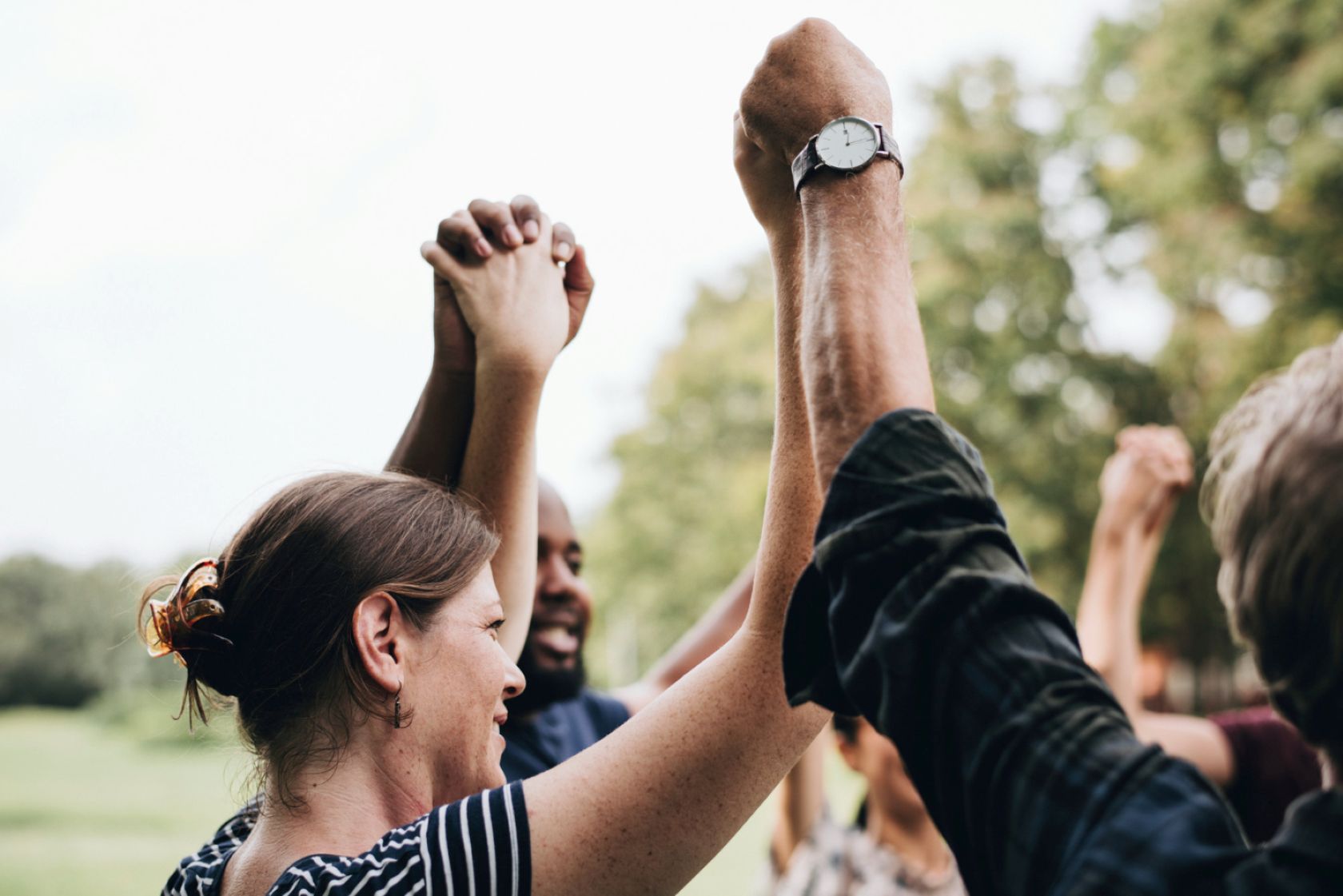 Christian equality means every person has equal worth before God. Believers raising their held hands together in triumph.