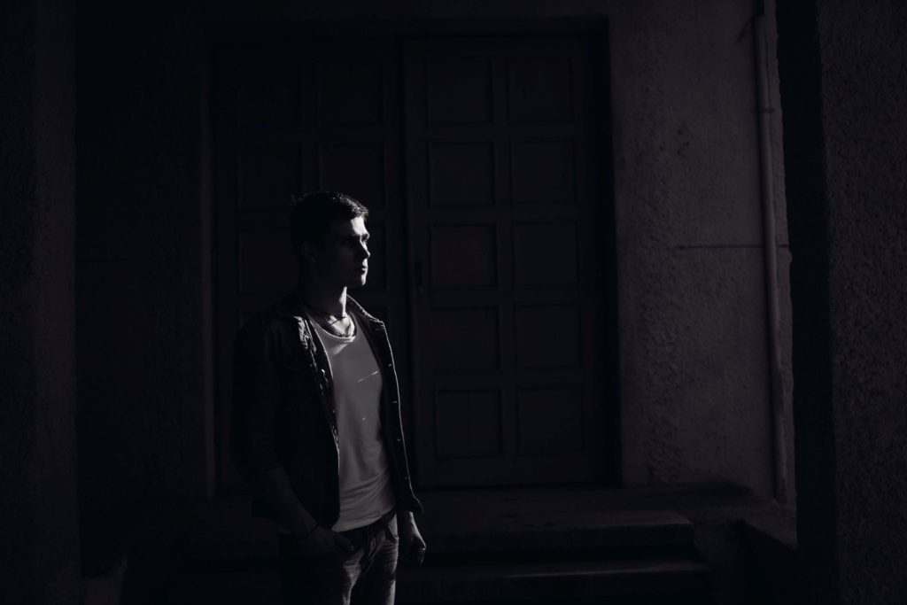 A man standing in darkness.